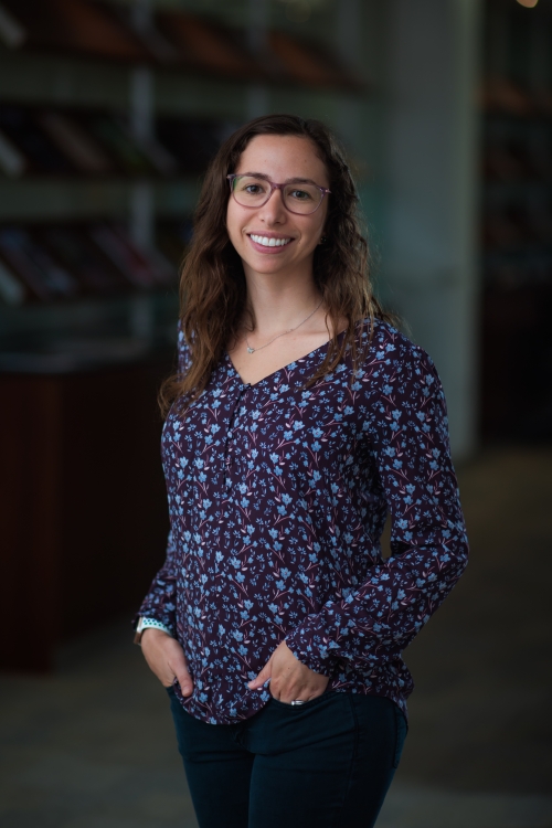 Jordana Bloom stands in a darkened room 