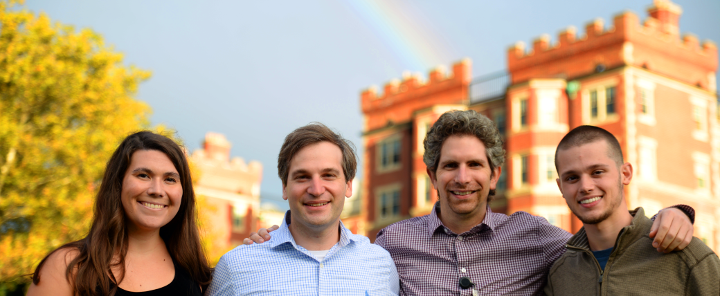 Scientists stand in front of a rainbow