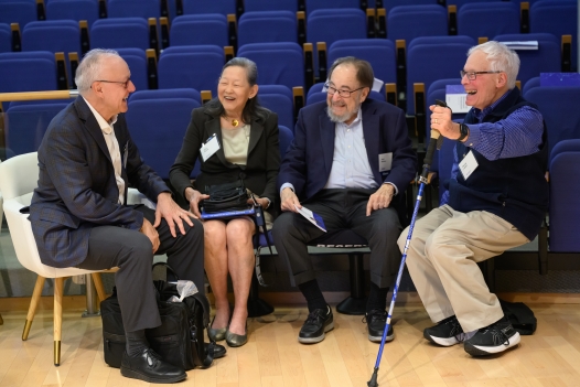 Baltimore and his wife sit with friends to either side of them in the front row of the auditorium